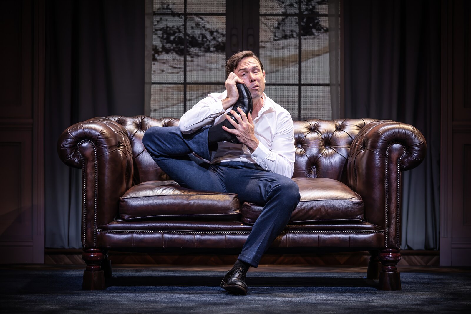 Sam Harrison comically holding a shoe like a telephone, Jeeves Takes Charge